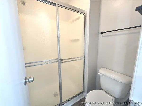 a white toilet sitting next to a shower