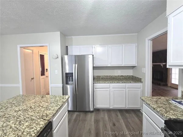 a kitchen with granite countertop a refrigerator and a stove