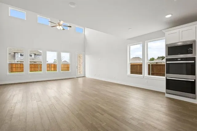 a kitchen with stainless steel appliances granite countertop a sink cabinets and wooden floor