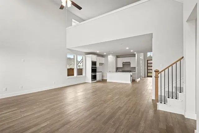 a view of a hallway with wooden floor and windows