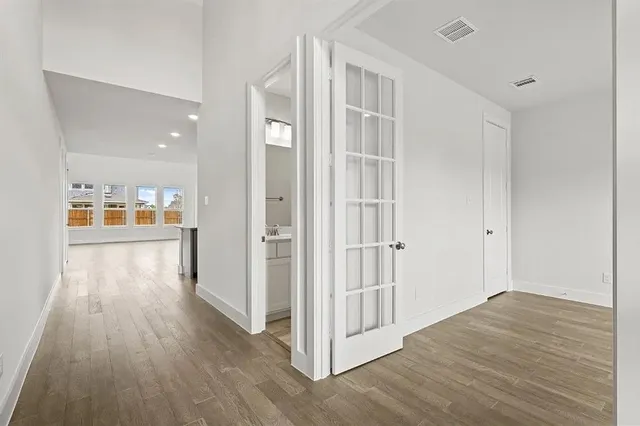 an empty room with wooden floor and windows