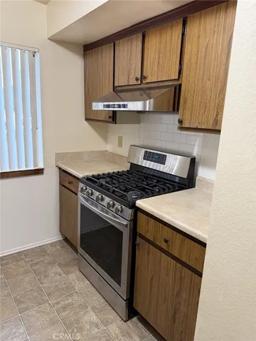 a kitchen with wooden cabinets and a stove top oven