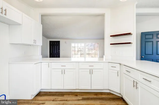 a view of a kitchen with white cabinets