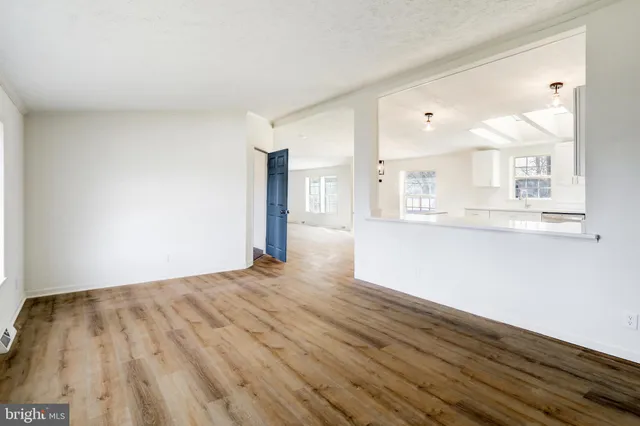 a view of a kitchen with wooden floor and a window