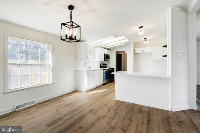 a view of a kitchen with wooden floor and windows