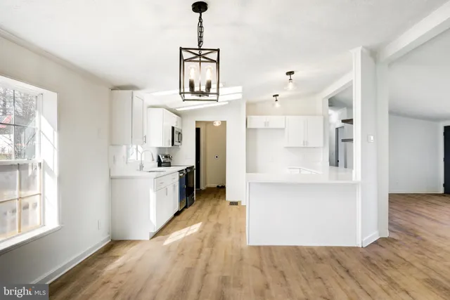 a view of a kitchen with wooden floor a kitchen view and a window