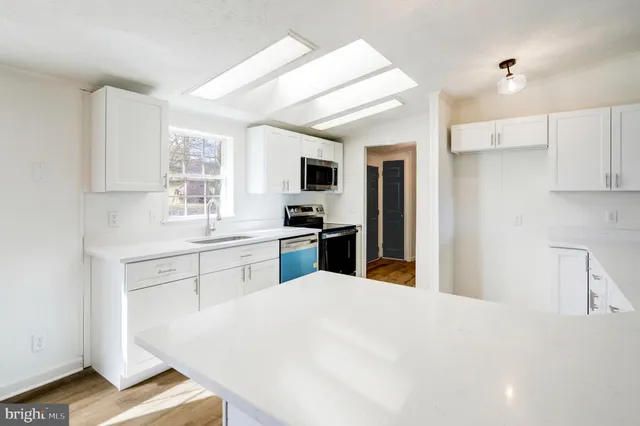 a kitchen with a refrigerator sink and cabinets