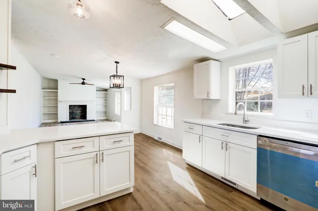 a kitchen with white cabinets and sink