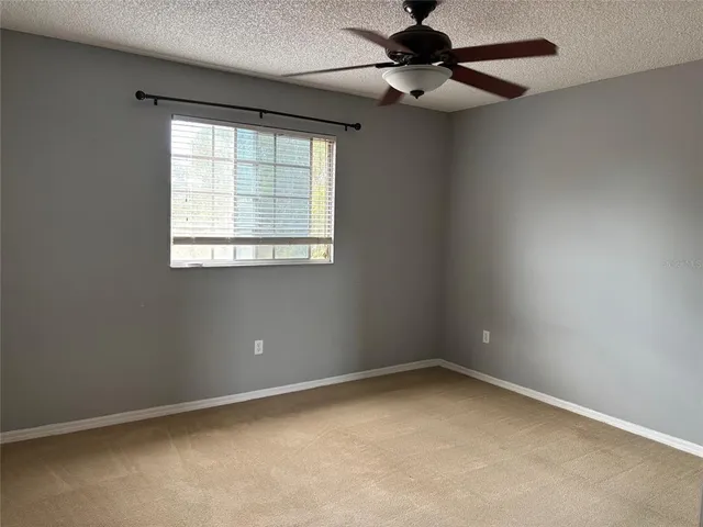an empty room with a window and a fan
