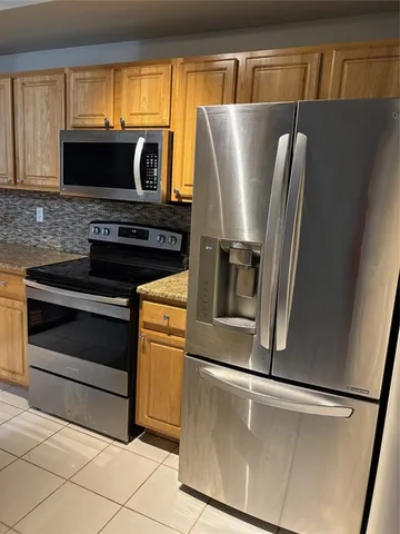 a view of kitchen with stainless steel appliances and cabinets