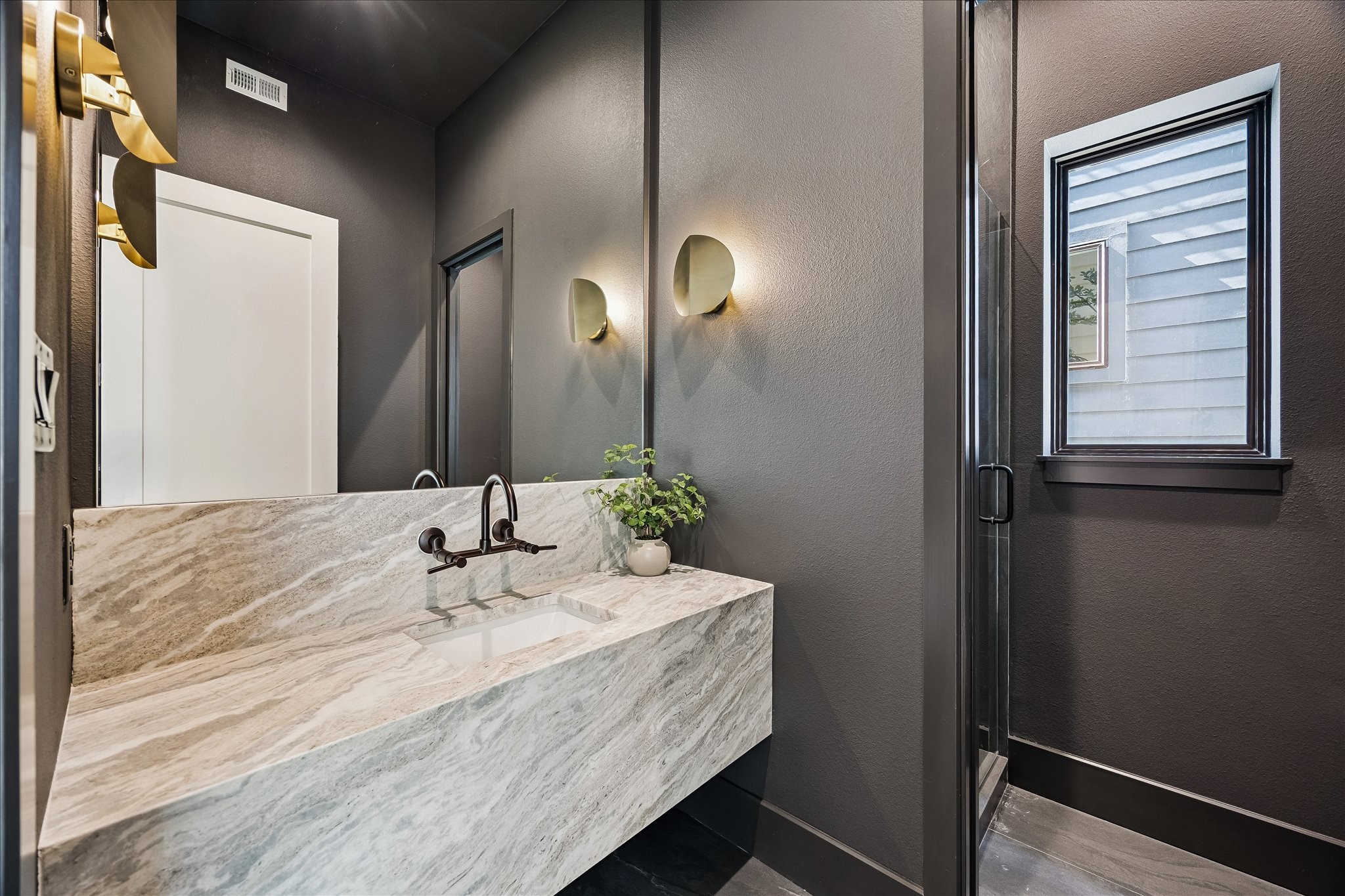 335 Harvard Street Houston, TX 77007 - Photo 13 of 35 Full bath features a floating sink with designer sconces and a walk-in shower.