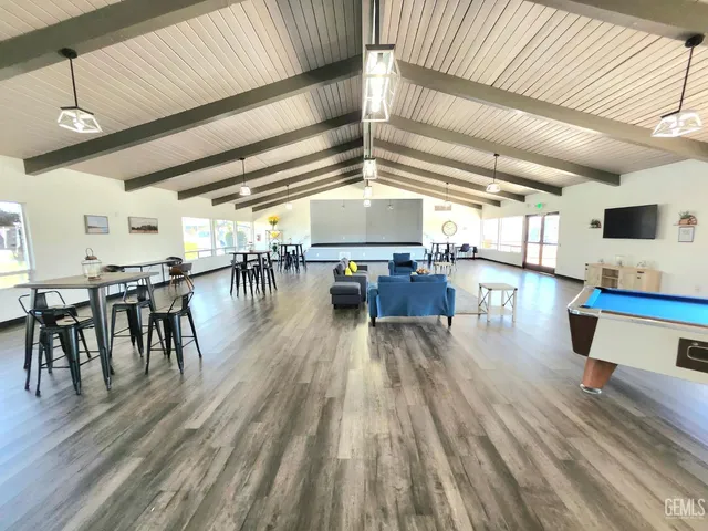 a hallway with wooden floors with table and chairs