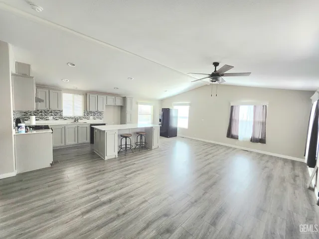 a view of a kitchen with wooden floor and electronic appliances