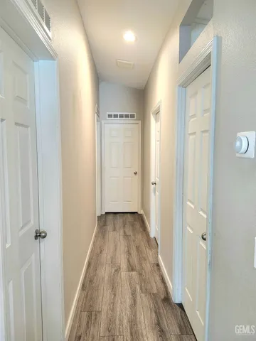 a view of a hallway with wooden floor