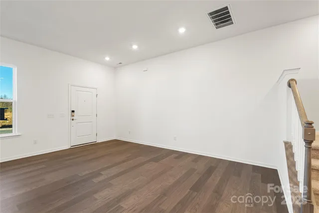 an empty room with wooden floor and white walls