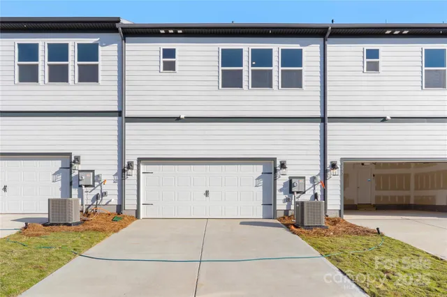 a view of a house with a yard and a garage
