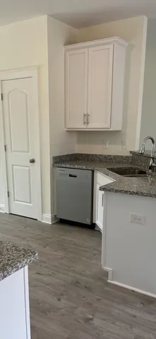 a kitchen with granite countertop cabinets and wooden floor