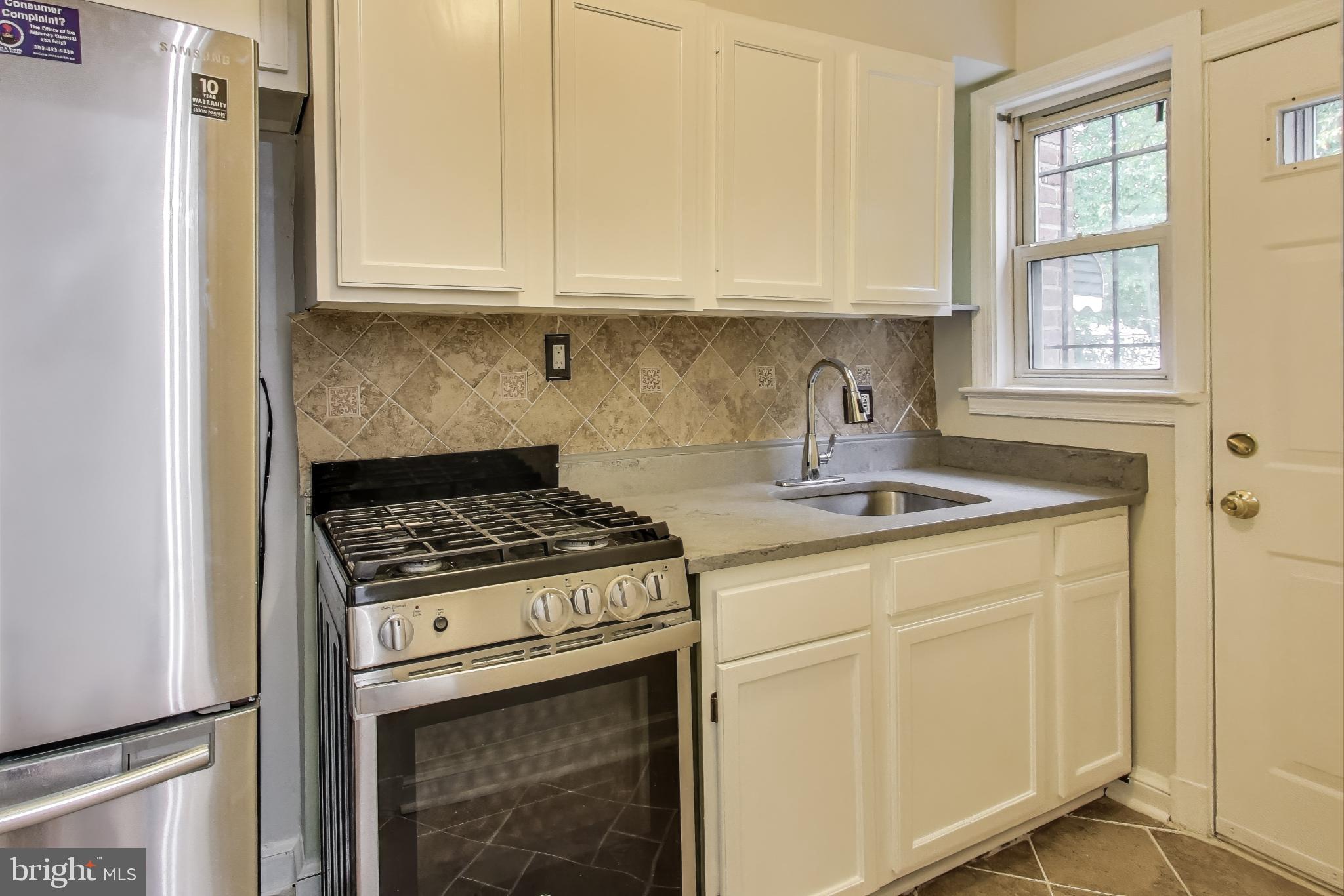 418 Peabody Street Northeast Washington, DC 20011 - Photo 5 of 20 a kitchen with granite countertop a stove sink and cabinets