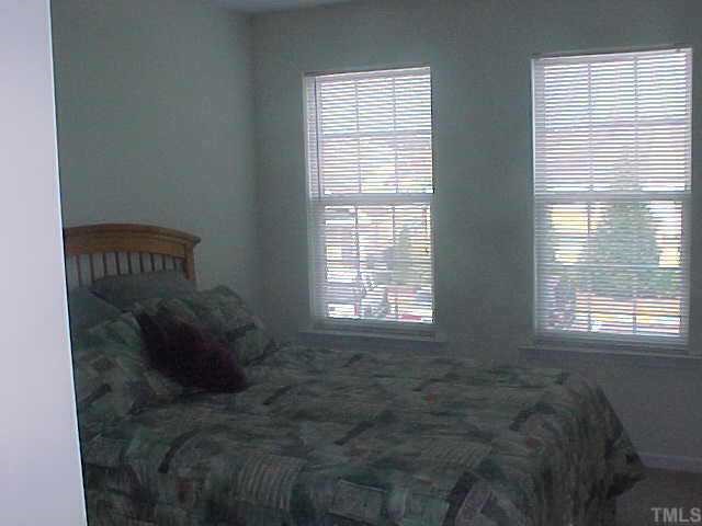 8443 Reedy Ridge Lane Raleigh, NC 27613 - Photo 7 of 10 a bed sitting in a bedroom next to a window