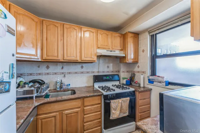 a kitchen with stainless steel appliances granite countertop a sink stove and cabinets