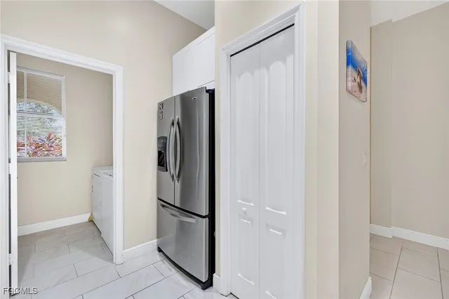a view of a refrigerator in kitchen and white cabinets