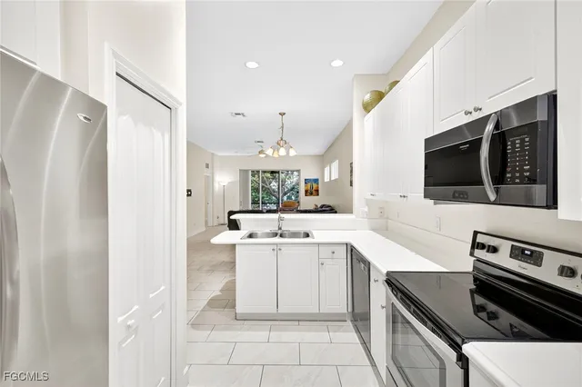 a kitchen with a sink stainless steel appliances and white cabinets