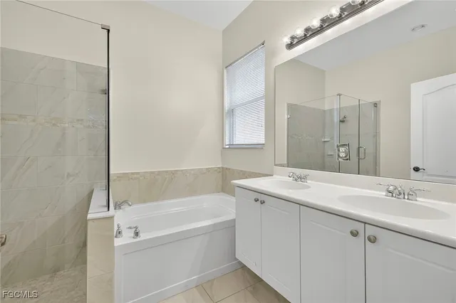 a bathroom with a granite countertop sink a mirror a bathtub and shower