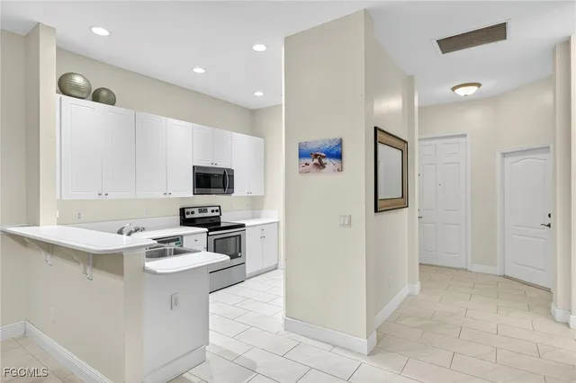 a kitchen with a sink a counter top space appliances and cabinets