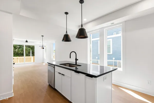 a kitchen with granite countertop a sink a counter top space appliances and cabinets