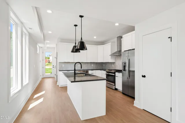 a view of a room with window wooden floor and front door