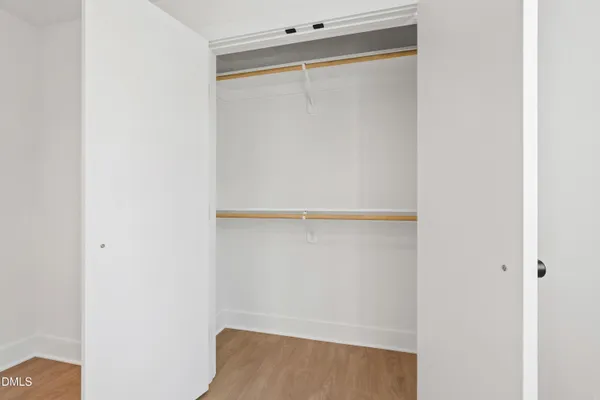 an empty room with window and wooden floor