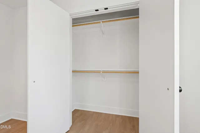 an empty room with window and wooden floor