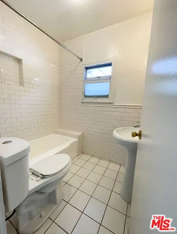 a bathroom with a toilet a sink a mirror and shower