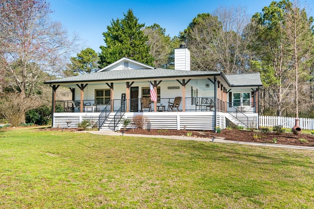 689 Austin Bridge Road Douglasville, GA 30134 - Photo 1 of 1 Beautiful farmhouse with a large wrap-around front porch, custom wrought iron railing, stained posts, and haint blue ceiling