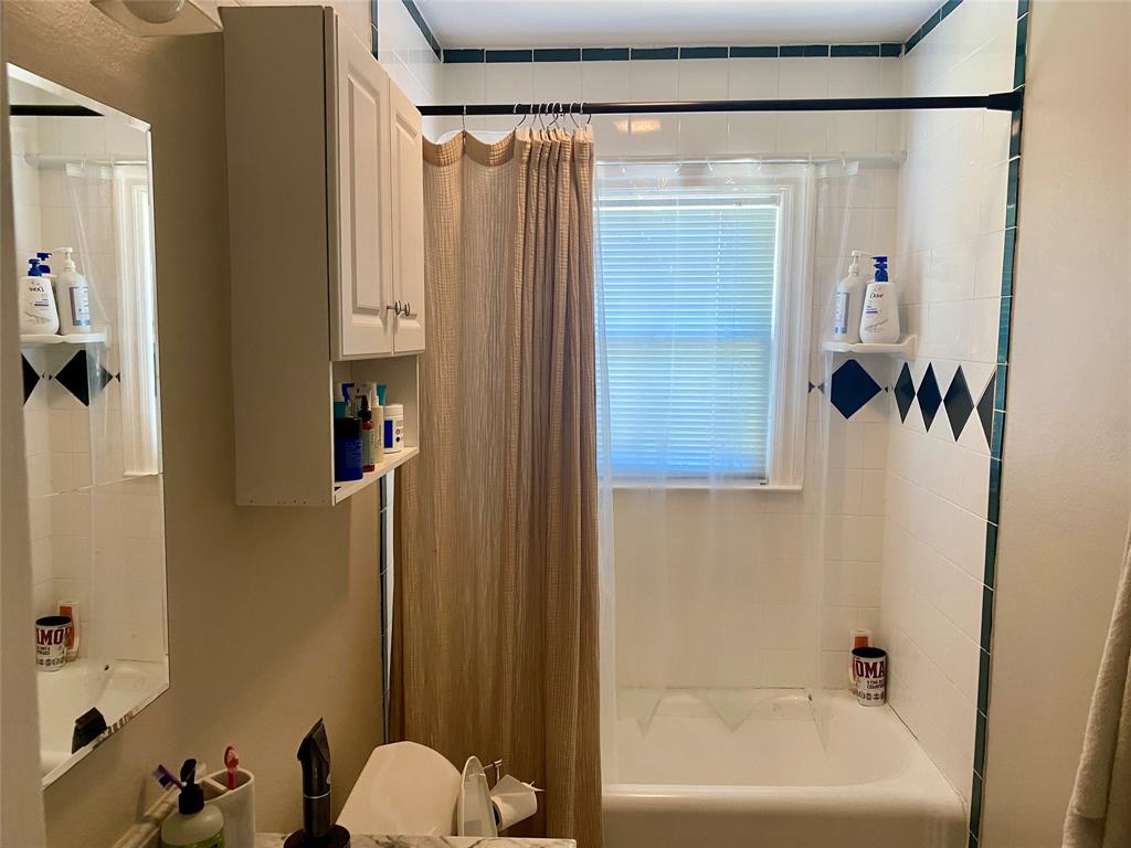 5949 Lewis Street Dallas, TX 75206 - Photo 8 of 10 a bathroom with a shower curtain and a window