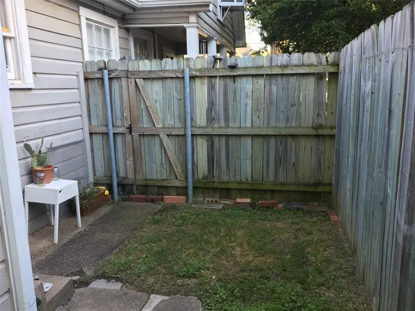 a view of a backyard with a chair and potted plants