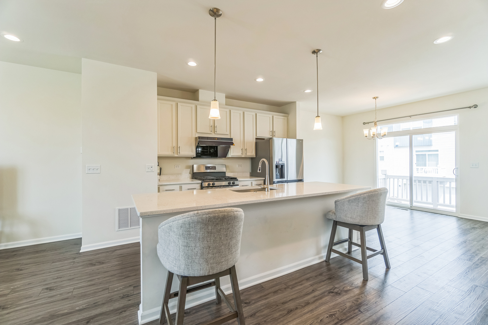 4138 Irving Road Aurora, IL 60504 - Photo 4 of 32 a kitchen with kitchen island a dining table chairs wooden floors and white cabinets