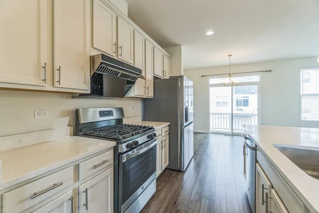 a kitchen with stainless steel appliances granite countertop a stove a sink and a refrigerator