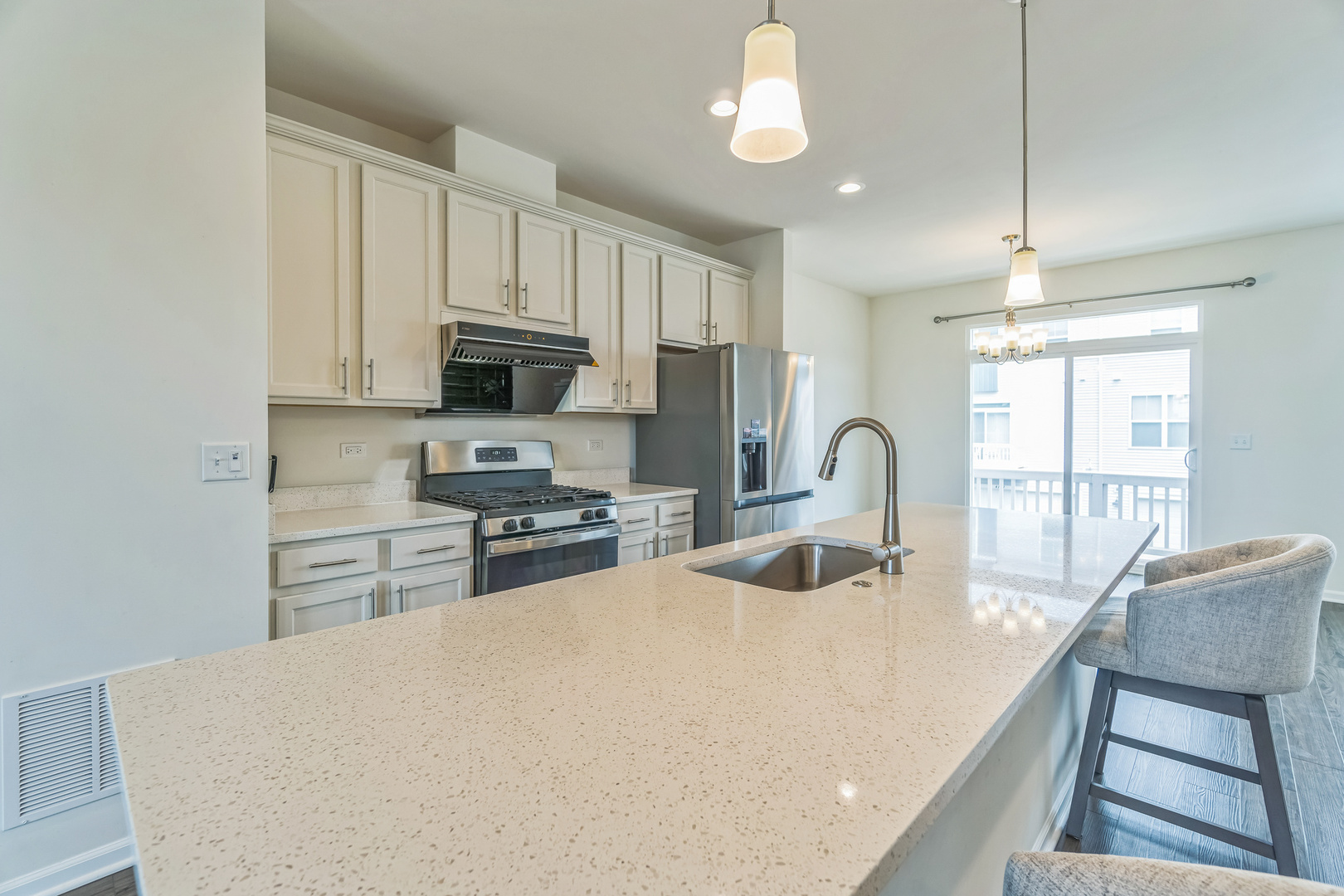 4138 Irving Road Aurora, IL 60504 - Photo 7 of 32 a kitchen with stainless steel appliances a stove a sink a microwave a refrigerator white cabinets and wooden floor