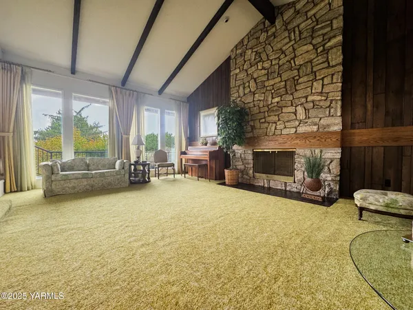 a view of a livingroom with furniture a fireplace and windows