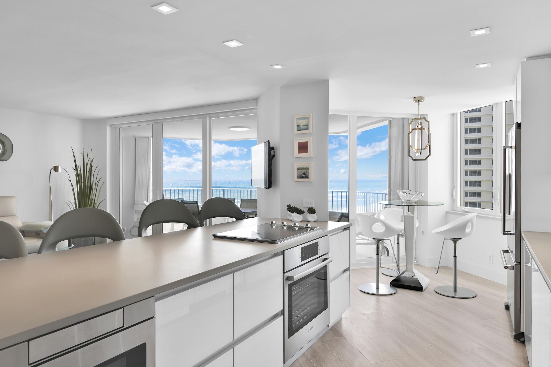 550 South Ocean Boulevard, Unit 1004 Boca Raton, FL 33432 - Photo 12 of 74 a open kitchen with stainless steel appliances a sink a stove and white cabinets with wooden floor