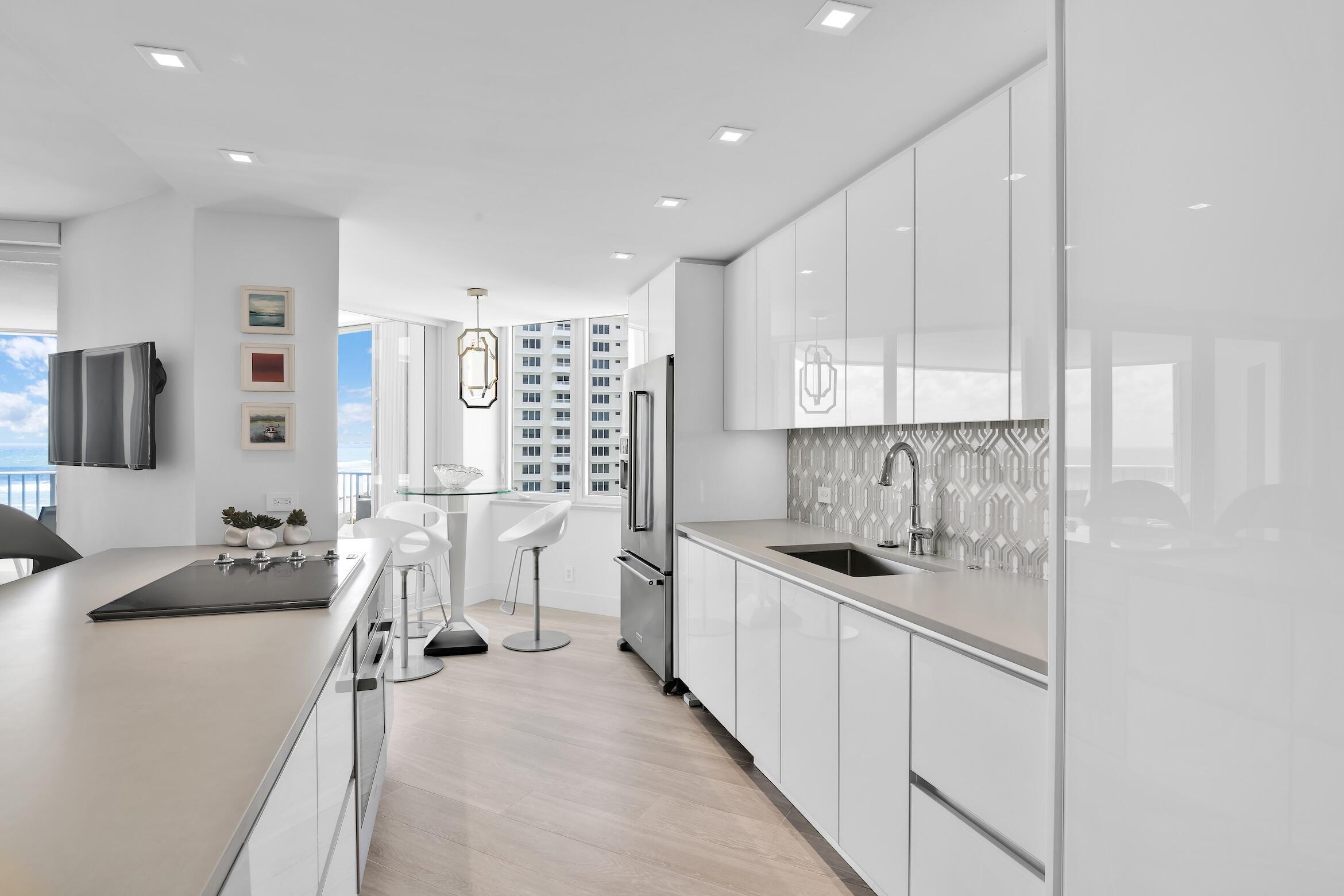 550 South Ocean Boulevard, Unit 1004 Boca Raton, FL 33432 - Photo 13 of 74 a kitchen with stainless steel appliances a sink stove and cabinets