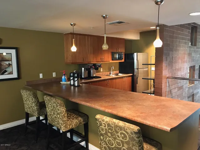 a kitchen with a table chairs and refrigerator