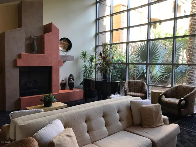 a living room with furniture fireplace and a large window