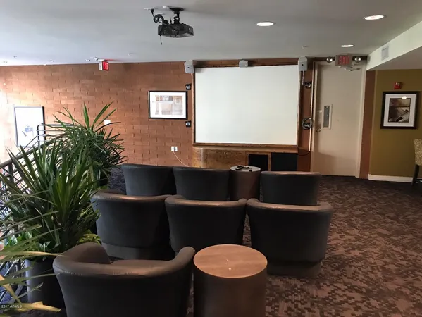 a living room with furniture a projector and a bookshelf