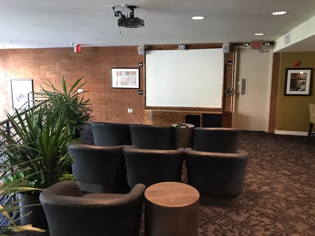 a living room with furniture a projector and a bookshelf