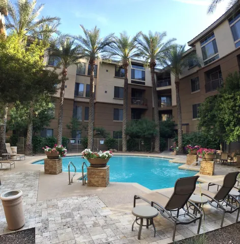a view of a chairs and tables in the patio in front of building