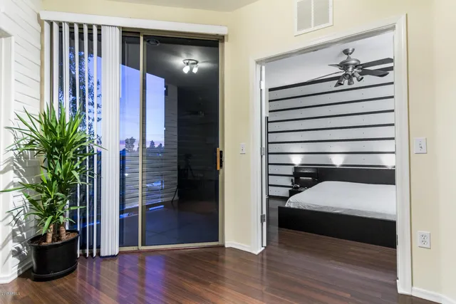 a view of a hallway with wooden floor and a potted plant