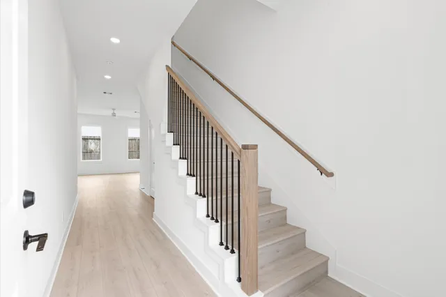 a view of a hallway with wooden floor and staircase