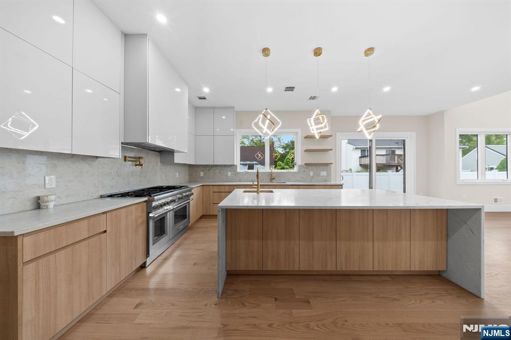 317 Edstan Way Paramus, NJ 07652 - Photo 11 of 48 a large kitchen with stainless steel appliances kitchen island granite countertop a large counter top a stove a sink and a refrigerator